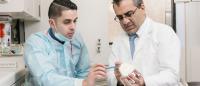 dental faculty teaching  a student with a dental tooth model
